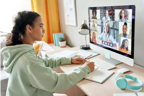Studentessa Diploma CSC che segue una lezione online in videochiamata per il recupero anni scolastici con tutor e compagni di studio