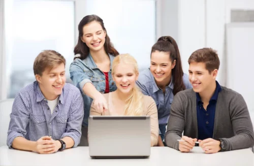 Gruppo di studenti al computer durante un percorso di recupero anni scolastici online