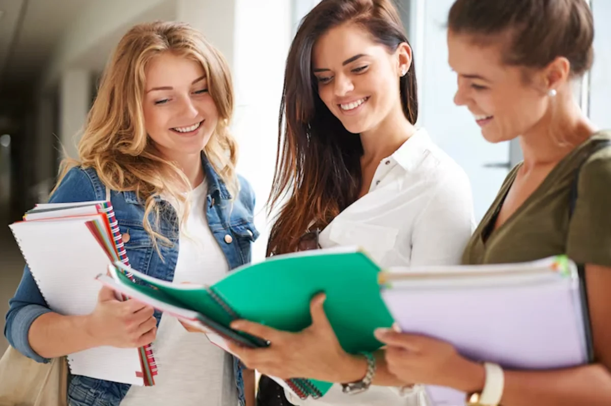 Studentesse che consultano libri per scegliere indirizzi scolastici online con Diploma CSC